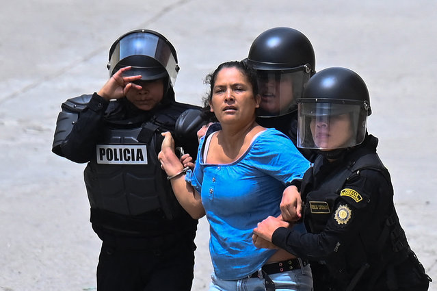 A woman is arrested as voters are dispersed by security forces outside a polling station which remains closed following alleged threats and irregularities during general elections, in San Jose del Golfo, on the northern outskirts of Guatemala City on June 25, 2023. Central America's most populous nation, Guatemala, votes for a new president that some hope, but few expect, will finally solve the problems of crushing poverty, violence and corruption. (Photo by Johan Ordonez/AFP Photo)