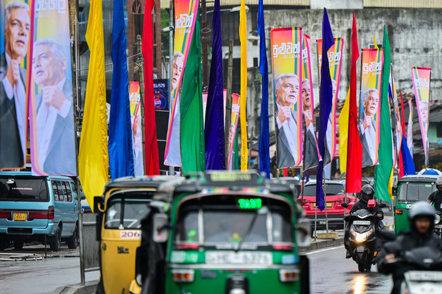 Commuters ride past posters of Sri Lanka's President Ranil Wickremesinghe, ahead of the country's presidential elections in Colombo on August 14, 2024. Sri Lanka's first presidential elections since an unprecedented economic crisis spurred widespread unrest will be held in September, the election commission said on July 26. (Photo by Ishara S. Kodikara/AFP Photo)