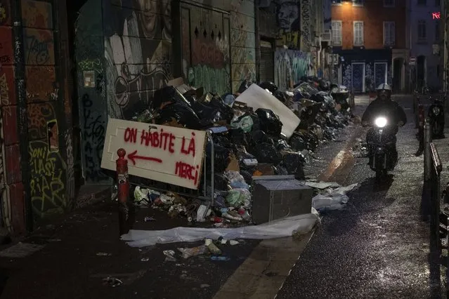 A sign reading “we live here, thank you” is hung over trash that has piled up during an eight-day-long garbage collectors strike in Marseille, southern France, Monday, October 4, 2021. (Photo by Daniel Cole/AP Photo)