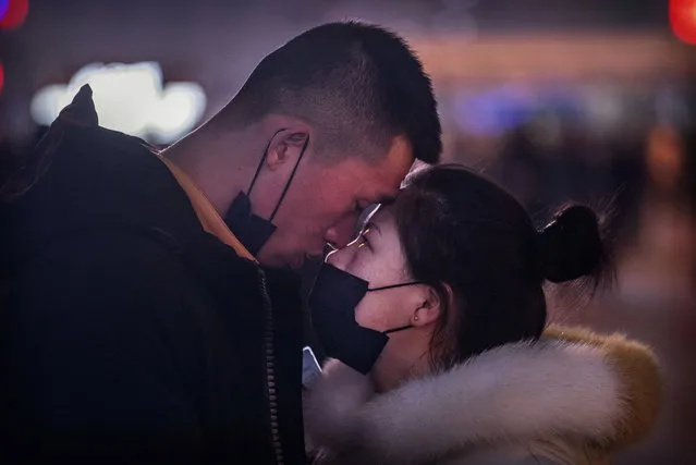 A Chinese man with his protective mask briefly pulled back shares a moment with his partner as she wears her protective mask before saying goodbye at Beijing Station before the annual Spring Festival on January 22, 2020 in Beijing, China. The number of cases of a deadly new coronavirus rose to over 400 in mainland China Wednesday as health officials stepped up efforts to contain the spread of the pneumonia-like disease which medicals experts confirmed can be passed from human to human. The number of those who have died from the virus in China climbed to nine on Wednesday and cases have been reported in other countries including the United States,Thailand, Japan, Taiwan and South Korea. (Photo by Kevin Frayer/Getty Images)