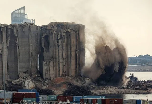 Part of the grain silos in the port of Beirut collapses, due to an ongoing fire since the beginning of last month, on August 4, 2022, on the day that crisis-hit Lebanon marks two years since a giant explosion ripped through the capital. On August 4, 2020, the dockside blast of haphazardly stored ammonium nitrate, one of history's biggest non-nuclear explosions, killed more than 200 people, wounded thousands and decimated vast areas of the capital. (Photo by Ibrahim Amro/AFP Photo)
