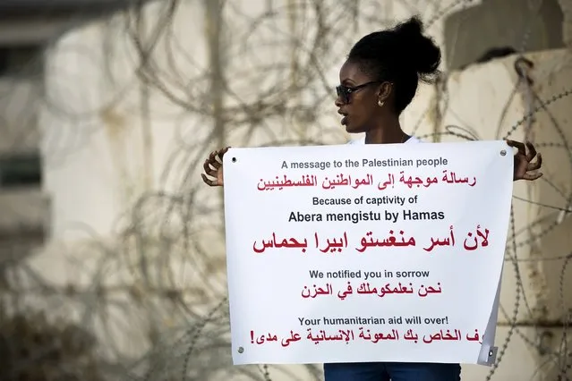 A demonstrator holds a placard during a protest calling for the release of Avraham Mengisto at the Erez Crossing in southern Israel, near the Gaza Strip August 27, 2015. Two Israeli citizens, one of them Mengisto, are being held by Hamas in the Gaza Strip, Prime Minister Benjamin Netanyahu said last month, a situation that could lead to demands for a prisoner exchange between Israel and the Islamist militant group. (Photo by Amir Cohen/Reuters)