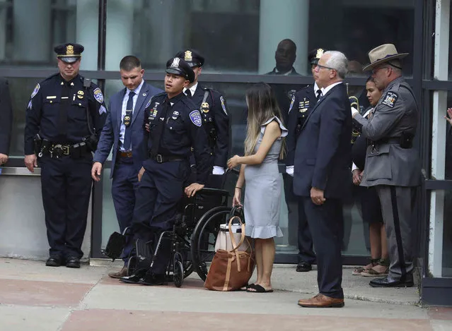 Rochester Police Officer Sino Seng stands up from his wheelchair so he can stand at attention as the cemetery procession lines up after the funeral for his partner, Officer Anthony Mazurkiewicz, at Blue Cross Arena in Rochester, NY., Monday, August 1, 2022. Seng was injured and Mazurkiewicz was killed in an ambush as they investigated a murder on July 21. (Photo by Tina MacIntyre-Yee/Democrat & Chronicle via AP Photo)