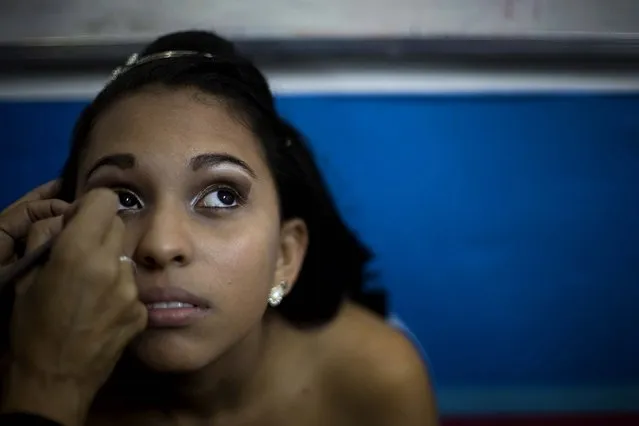 A girl holds still for make-up before the debutante ball.  All of the debutantes turned 15 this year, but few had the means to celebrate the milestone with one of the lavish blowouts that are de rigueur among wealthier Brazilians. (Photo by Silvia Izquierdo/AP Photo via The Palm Beach Post)