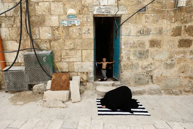 A Muslim woman prays during the first Friday prayer of Ramadan in an alley in Jerusalem's Old City amid the coronavirus disease (COVID-19) restrictions April 24, 2020. (Photo by Ammar Awad/Reuters)