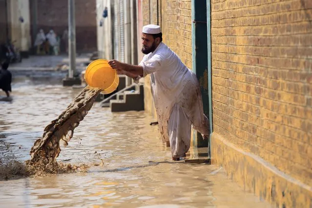 A man throws water out of his home after floods in Nowshera District, Khyber Pakhtunkhwa province, Pakistan, 30 August 2022. (Photo by Bilawal Arbab/EPA/EFE)