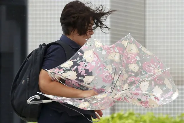 A person braves the strong wind caused by Typhoon Hinnamnor in Naha, Okinawa prefecture, Japan Sunday, September 4, 2022. (Photo by Kyodo News via AP Photo)