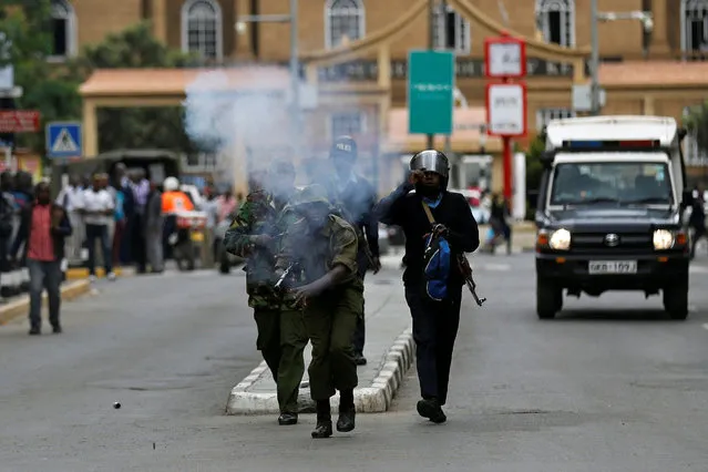 Riot policemen fire tear gas to disperse supporters of Kenyan opposition National Super Alliance (NASA) coalition during a protest along a street in Nairobi, Kenya October 24, 2017. (Photo by Thomas Mukoya/Reuters)