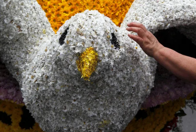 A woman prepares a flower arrangement during the annual flower parade in Medellin, Colombia, August 7, 2016. (Photo by Fredy Builes/Reuters)