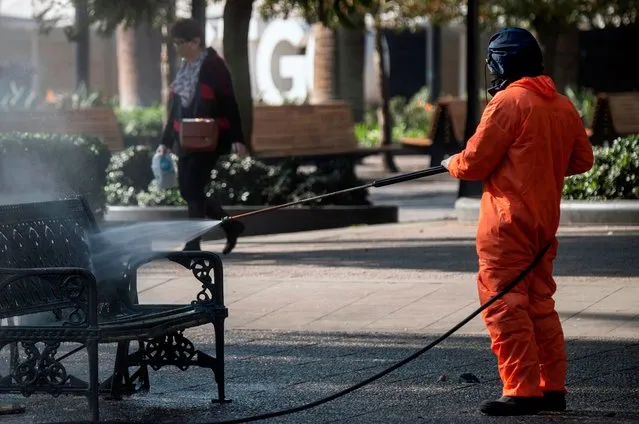 A Municipality worker cleans and disinfects the Mayor square in Santiago, on June 10, 2020 amid the new coronavirus pandemic. (Photo by Martin Bernetti/AFP Photo)