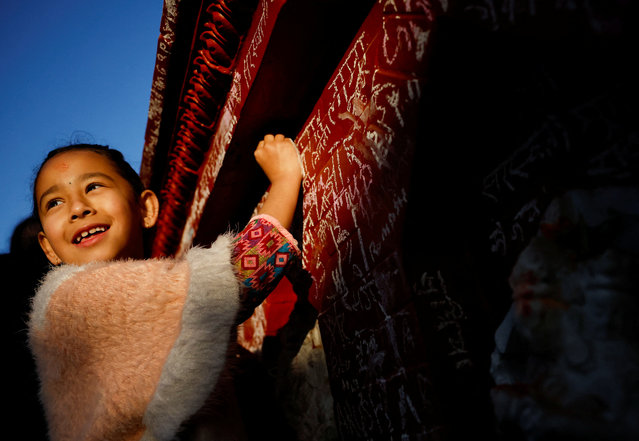 A girl smiles as she writes on the wall of a Saraswati temple during the Shreepanchami festival, dedicated to the goddess of education Saraswati in belief that the goddess will help devotees excel in education, in Kathmandu, Nepal on February 3, 2025. (Photo by Navesh Chitrakar/Reuters)