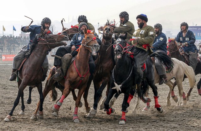 Players from the Kunduz and Samangan teams struggle to catch the goat carcass during semi-final game of Buzkashi league in Kabul, Afghanistan, 03 January 2024. Several provincial teams are participating in the Buzkashi league. Buzkashi is a traditional sport in which horse-mounted players attempt to place a goat or calf carcass in a goal. (Photo by Samiullah Popal/EPA)