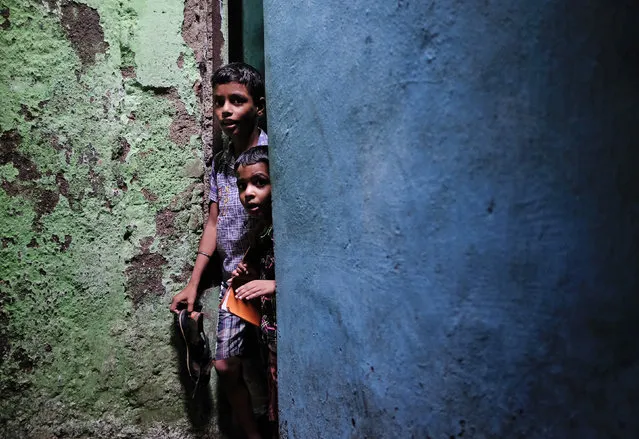 Schoolchildren walk through an alley after attending private tuition at a slum in Mumbai July 16, 2014. (Photo by Danish Siddiqui/Reuters)