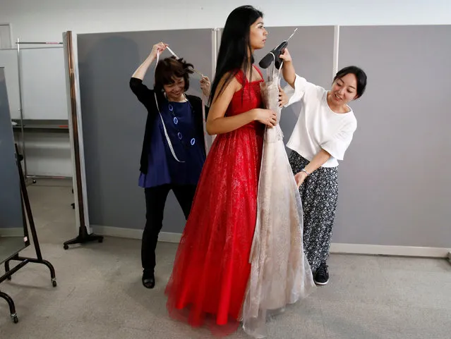 Designers helps Priyanka Yoshikawa, winner of Miss World Japan 2016, try on a dress as she chooses a costume which she is going to wear in the Miss World competition, at a designer's atelier in Tokyo, Japan, September 7, 2016. (Photo by Kim Kyung-Hoon/Reuters)