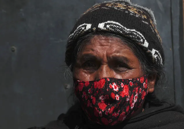 A woman wearing a protective face mask speaks with healthcare workers during a house-to-house campaign to help curb the spread of the new coronavirus, in the Mallasa neighborhood of La Paz, Bolivia, Saturday, August 8, 2020. (Photo by Juan Karita/AP Photo)