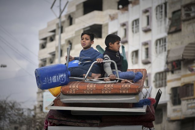Two boy sit on a mattress as they ride on their family car while s fleeing from east to west of Gaza City after the Israeli military issued evacuation orders in the area, Friday April 11, 2025. (Photo by Jehad Alshrafi/AP Photo)