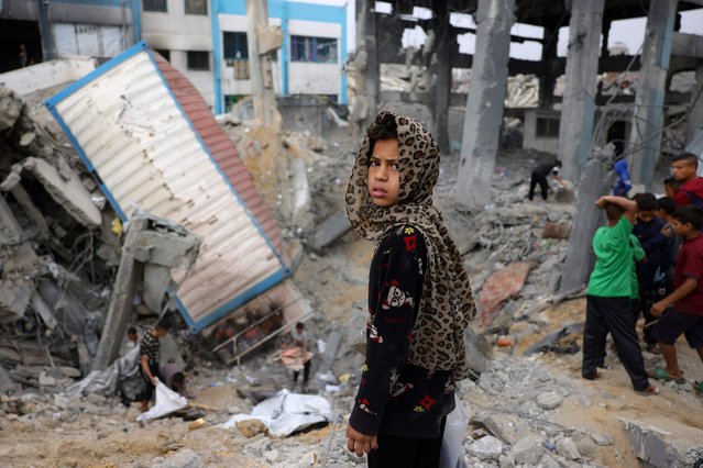 A young Palestinian girl looks on as children gather amid the rubble of an UNRWA school-turned-shelter, heavily damaged in an overnight Israeli strike in Jabalia in the northern Gaza Strip on May 10, 2025. (Photo by Bashar Taleb/AFP Photo)