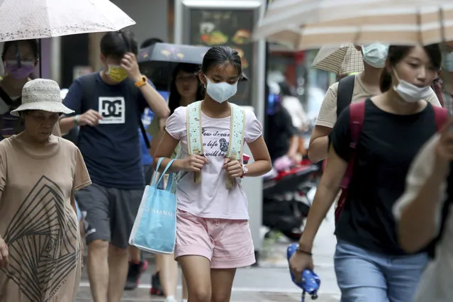 People wearing face masks to protect against the spread of the coronavirus walk in Taipei, Taiwan, Saturday, August 22, 2020. (Photo by Chiang Ying-ying/AP Photo)