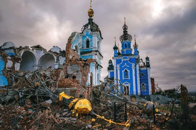 Construction workers climb onto the roof of a destroyed church in the village of Bohorodychne, Donetsk region on January 4, 2023, amid the Russian invasion of Ukraine. Bohorodychne is a village in Donetsk region that came under heavy attack by Russian forces in June 2022, during the Russian invasion of Ukraine. On August 17, 2022 the Russian forces captured the village. The Armed Forces of Ukraine announced on September 12, 2022 that they took back the control over the village. A few resident came back to restore their destroyed houses and live in the village. (Photo by Dimitar Dilkoff/AFP Photo)