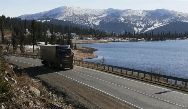 A truck drives along the M54 "Yenisei" highway in the Western Sayan mountains along the bank of the Oyskoye Lake near an administrative border with Tuva region south of Krasnoyarsk, Southern Siberia, Russia, October 11, 2015. (Photo by Ilya Naymushin/Reuters)