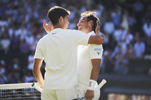 Carlos Alcaraz of Spain, left, greets Fabio Fognini of Italy at the net after winning their first round men's singles match at the Wimbledon Tennis Championships in London, Monday, June 30, 2025. (Photo by Alastair Grant/AP Photo)