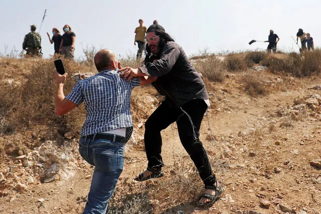 A Palestinian demonstrator scuffles with an Israeli settler during a Palestinian protest against Jewish settlements and normalizing ties with Israel, in Asira al-Qibliya town in the Israeli-occupied West Bank on September 18, 2020. (Photo by Mohamad Torokman/Reuters)