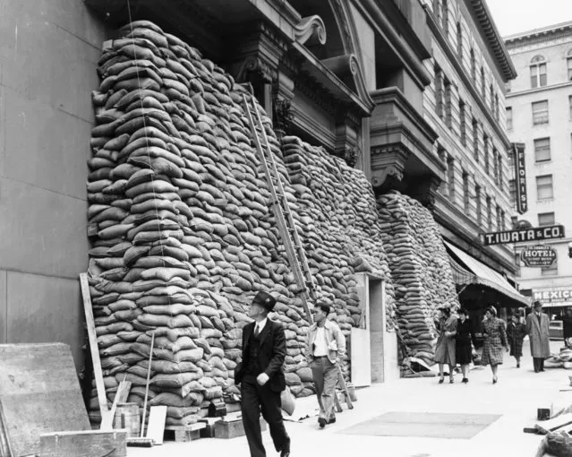 As protection against possible Japanese air raids, sandbags are piled as high as the second story against the telephone company building in San Francisco, on December 13, 1941. (Photo by Jack Rice/AP Photo)