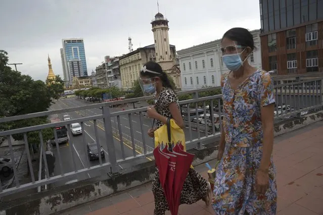 Pedestrians wearing face shields and masks walk at an overhead crossing at Sule Pagoda Road in Yangon, Myanmar,Monday, September 21, 2020. Myanmar, faced with a rapidly rising number of coronavirus cases and deaths, has imposed the tightest restrictions so far to fight the spread of the disease in Yangon, the country's biggest city and main transportation hub. (Photo by Pyae Sone Win/AP Photo)