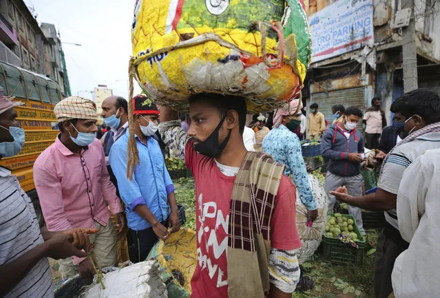 Daily wage laborers and fruit vendors wear face masks as a precaution against coronavirus at a wholesale market in Bengaluru, India, Thursday, September 24, 2020. (Photo by Aijaz Rahi/AP Photo)