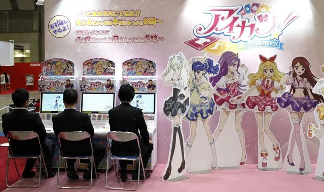 Visitors sit next to cardboard cutouts of anime characters at a booth at the Tokyo International Anime Fair at Tokyo Big Sight on Thursday, on March 22, 2013. The fair, one of the world’s largest animation expos, runs until Sunday and is expected to attract around 100,000 visitors, according to organizers. (Photo by Yuya Shino/Reuters)