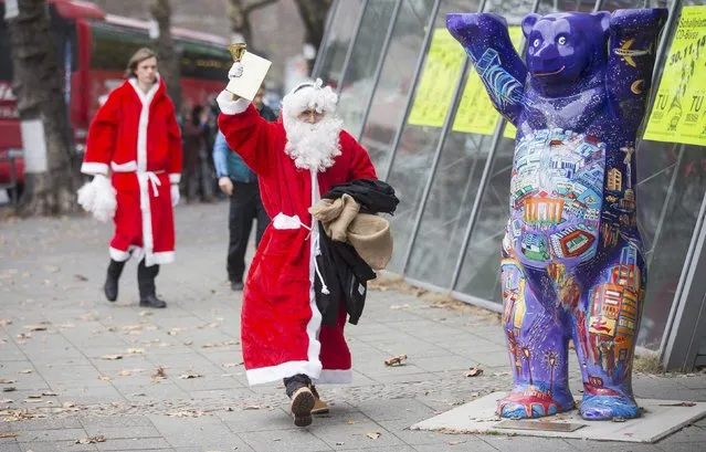 A man dressed as Santa Claus leaves the annual meeting of participants of a university rent-a-Santa Claus service in Berlin November 29, 2014. Some 100 people in Santa Claus and fairy costumes met on Saturday in Berlin for a general meeting to launch the annual Student Union charitable Santa Claus rental campaign. (Photo by Hannibal Hanschke/Reuters)