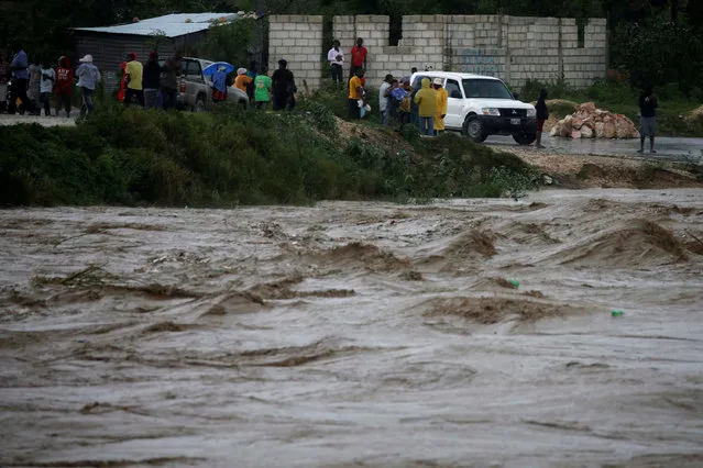 People inspect the rising water level of a river due to the rains caused by Hurricane Matthew passing through Port-au-Prince, Haiti, October 4, 2016. (Photo by Carlos Garcia Rawlins/Reuters)