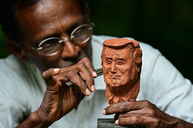 Upali Dias, a Sri Lankan sculptor, adds the final touches to a clay bust of US President Donald Trump at his residence near Colombo on April 10, 2025. US President Donald Trump abruptly paused tariffs on most countries, sparking euphoria on global markets Thursday, but upped the ante on a brutal trade war with superpower rival China. (Photo by Ishara S. Kodikara/AFP Photo)