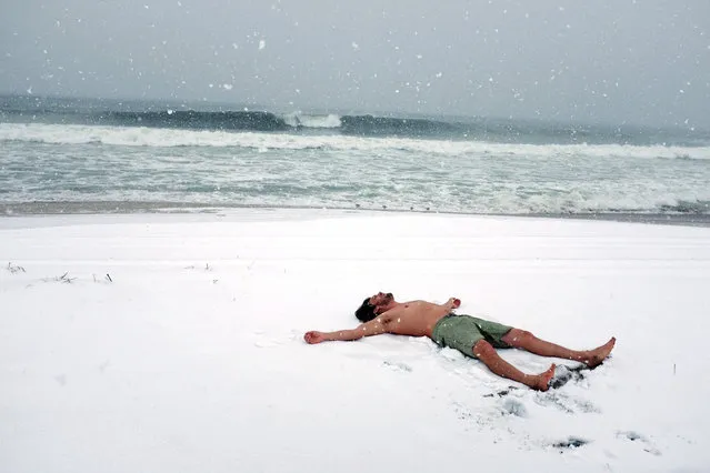 Bobby Reynolds lays on the snowy beach before surfing at Rockaway Beach during a snow storm March 21, 2018 in the Queens borough of New York. New York City and much of New England has experienced four Nor'easter winter storms in recent weeks. (Photo by Bryan Bedder/Getty Images)