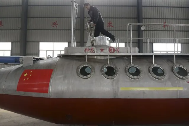 Zhang Junlin, a 62-year-old retired prison guard, enters his homemade submarine named “Shenlong-3” at a factory in Fuyang, Anhui province December 20, 2014. (Photo by Reuters/China Daily)