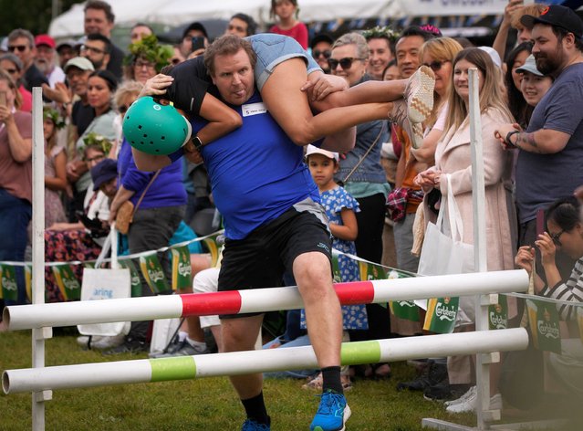 Competitors take part in a wife-carrying contest in Burnaby, British Columbia, Canada, on June 23, 2024. (Photo by Xinhua News Agency/Rex Features/Shutterstock)