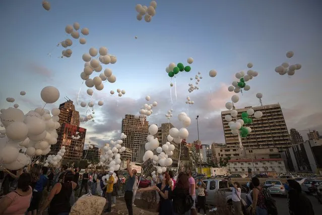 People release scores of white balloons bearing the names of the Aug. 4 blast victims at about 6:07 p.m., when the deadly explosion occurred, to mark the two-month anniversary, next to the seaport of Beirut, Lebanon, Sunday, October 4, 2020. (Photo by Hassan Ammar/AP Photo)