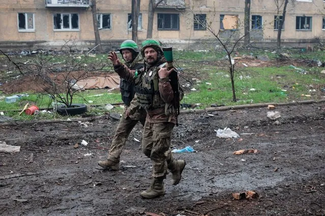 Ukrainian soldiers wave in war-hit Bakhmut, Donetsk region, Ukraine, Wednesday, April 12, 2023. (Photo by Iryna Rubakova via AP Photo)