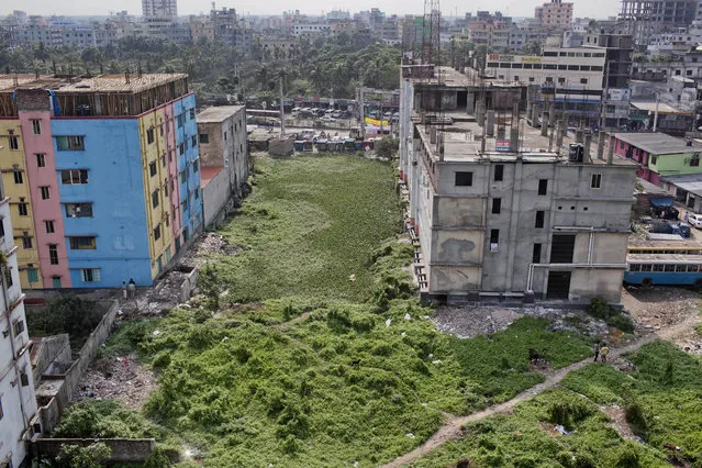 In this April 18, 2018 photo, overgrown bushes cover the area where the Rana Plaza garment factory building stood before it collapsed five years ago in Savar, Bangladesh. A new survey says that five years after the garment factory collapse in Bangladesh killed 1,134 people and left thousands injured some things have changed for the better for the workers who toiled in the country's huge garment industry but much remains to be done. The survey by the Center for Business and Human Rights at New York University's Stern School of Business found that the largest factories generally have complied with new safety standards set by foreign clothing brands since the 2013 accident. (Photo by A.M. Ahad/AP Photo)