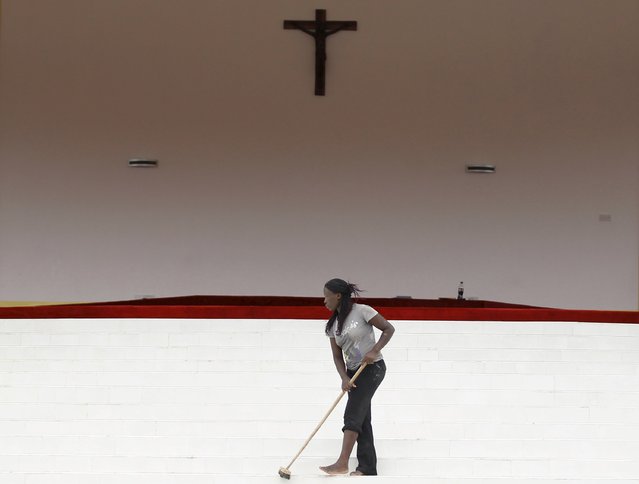A volunteer sweeps the altar specially built for the Papal Mass ahead of the visit of Pope Francis in Kenya's capital Nairobi, November 24, 2015. (Photo by Thomas Mukoya/Reuters)