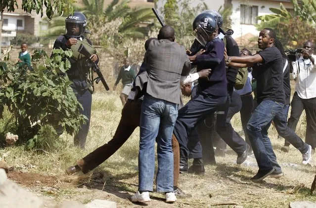 Riot police scuffle with members of the civil society after they demolished a perimeter wall erected by a private developer around Langata primary school playground in Kenya's capital Nairobi, January 19, 2015. (Photo by Thomas Mukoya/Reuters)