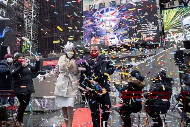 Denise and Robert Marte, wearing protective masks, walk down a red carpet after exchanging their vows at their Valentine's Day wedding ceremony in Times Square in Manhattan, New York City, New York, U.S., February 14, 2021. (Photo by Jeenah Moon/Reuters)