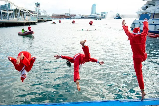 Participants sporting Santa Claus costumes jump into the water during the 111th edition of the Copa Nadal (Christmas Cup) swimming race in Barcelona's Port Vell on December 25, 2020. The traditional 200-meter Christmas swimming race gathered around 300 participants on Barcelona's Port Vell (old harbour). (Photo by Josep Lago/AFP Photo)