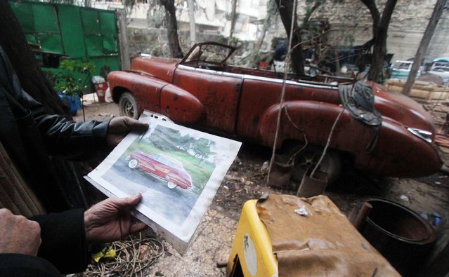 Mohamed Badr al-Din stands in front of one of his vintage cars as he holds up a photo of a car used to transport presidents and officials during ceremonies, in the al-Shaar neighborhood of Aleppo January 31, 2015. (Photo by Abdalrhman Ismail/Reuters)