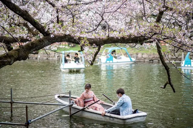 People ride boats watching cherry blossoms at Inokashira Park in Tokyo on March 30, 2021. (Photo by Philip Fong/AFP Photo)