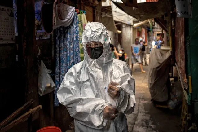 Katrina Pelotin, a field nurse from the City Epidemiology and Surveillance Unit, is seen wearing protective clothing as her team conducts contact tracing efforts at a slum area on April 15, 2021 in Quezon city, Metro Manila, Philippines. As the Philippines experiences its worst surge in COVID-19 cases since the beginning of the pandemic, many Covid-19 patients are being forced to suffer at home, missing out on vital care due to overwhelmed hospitals and raising the risk of infecting family members. The country is currently suffering the worst Covid-19 outbreak in Southeast Asia with more than 904,000 confirmed cases and with nearly one in four people being tested turning out positive. (Photo by Ezra Acayan/Getty Images)