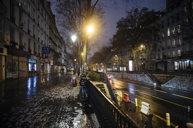 An empty street as the 6 p.m curfew starts in Paris, Saturday January 16, 2021. The prime minister announced Thursday an extension of the 6 p.m.-to-6 a.m. curfew to cover the whole country, including zones, like Paris, where it previously hadn't started until 8 p.m. Shopping and all outdoor leisure activities stop at curfew, only short pet walks allowed. Working and commuting allowed with note from employer. Food deliveries but not takeout allowed. Fines for curfew-breakers. (Photo by Lewis Joly/AP Photo)