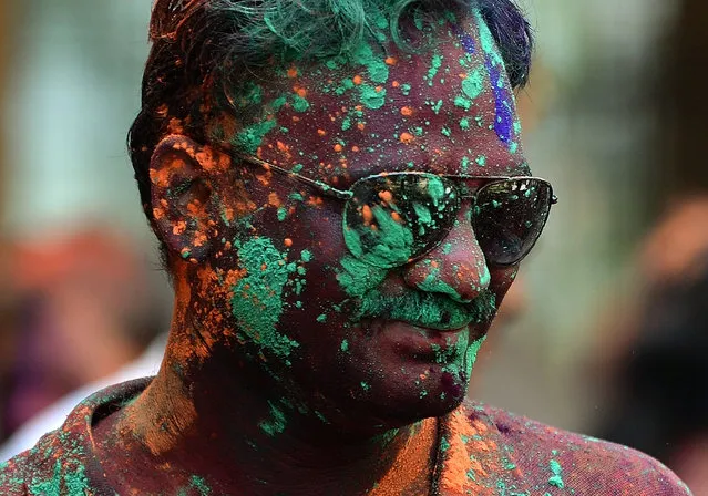 An Indian youth is covered with coloured powder during Holi celebrations in Mumbai on March 6, 2015.  Holi, the festival of colours, is a riotous celebration of the coming of spring and falls on the day after full moon annually in March. Revellers spray coloured powder and water on each other with great gusto, whilst adults extend the hand of peace.  AFP PHOTO / PUNIT PARANJPE        (PUNIT PARANJPE/AFP/Getty Images)