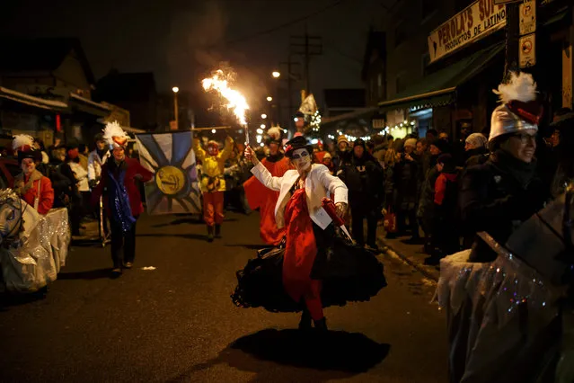 A performer leads the parade with fire during the 27 th Annual Kensington Market Winter Solstice Parade in Toronto on December 21, 2016. (Photo by Cole Burston/AFP Photo)