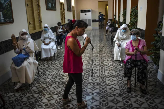 A woman sings for people who have just been inoculated with the Cuban Abdala COVID-19 vaccine as they wait in the observation area in Havana, Cuba, Wednesday, June 23, 2021. (Photo by Ramon Espinosa/AP Photo)